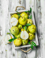Fresh pears with leaves on tray.