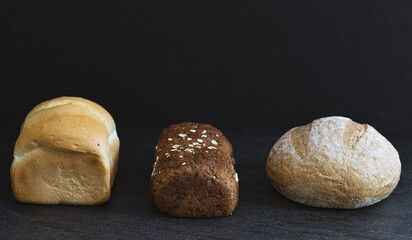 Three different varieties of breads on a black background.
