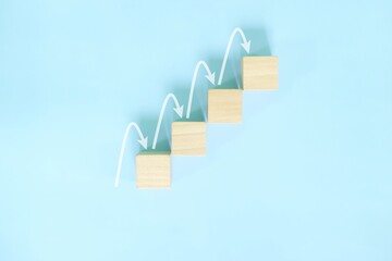 Ladder of success, positive outlook and step by step or gradual growth concept. Wooden blocks in blue background.