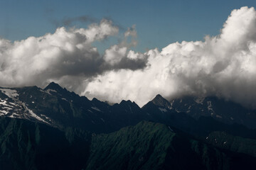 Obraz premium Beautiful mountain landscape, clouds over the peaks of the mountains, sunny day