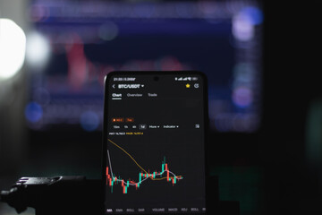 Candlestick chart showing price of cryptocurrencies like Bitcoin on sideway trend in bear market display on smartphone screen.Idea: Money management and investment during the crypto winter.