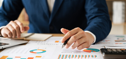 Concept of business growth and financial investment, executives use laptop computers to analyze sales data and economic growth graphs, business planning and strategy.