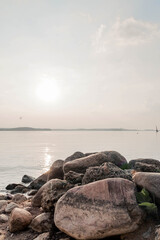 Coastal stones and lake water at summer sunset