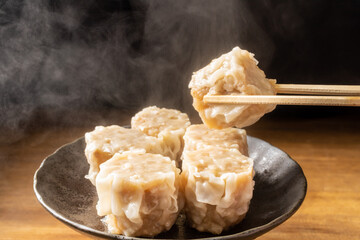 蒸しあがった焼売を持ち上げる
