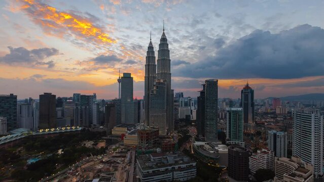 Aerial high angle sunset time lapse of golden time lapse with a wide angle view of a skyline at dusk in Kuala Lumpur, Malaysia. Tilt down motion timelapse. Prores 4K DCI