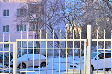 Metal fence parking near a residential building on a winter day