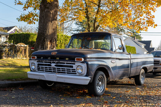 Black Ford F100 Pickup. 1965 retro Ford parked at the street side on sunny autumn day. Snohomish, WA, USA - October 2022