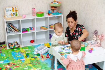 Grandmother and toddlers playing with matching puzzle