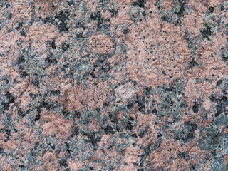 Granite texture. Natural pink granite with a grainy pattern. Stone background. Solid rough surface of rock. Durable construction and decoration material. Close-up.