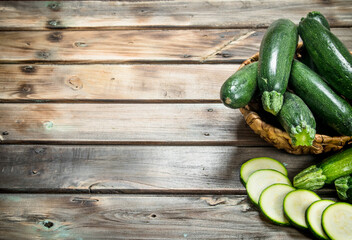 The whole zucchini the basket and slices of zucchini.
