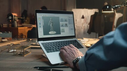 Fashion designer creates clothes and develops future wear collection in 3D modeling program. Male tailor works in luxury designer workshop or tailoring studio on laptop. Fashion concept.