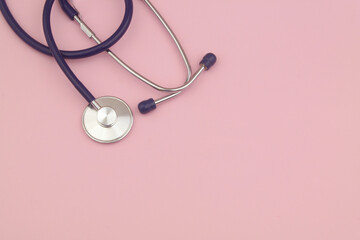 Stethoscope on pink background. Large copy space for text. Medicine and health care concept.