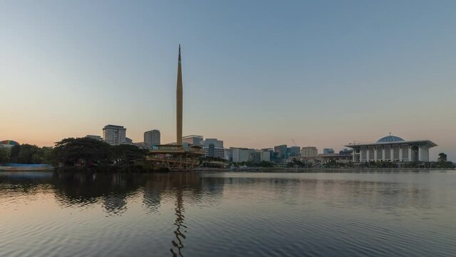 Beautiful clear morning time lapse by a lake with hot air balloons flying from afar in the background in Putrajaya, Malaysia. Zoom out motion timelapse. Prores 4KUHD