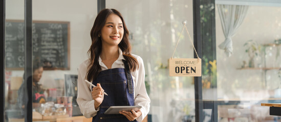 Young asia business owner woman with apron with open sign at café, open again © NanSan