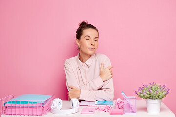 Pretty young lady woman, takes a minute of break at the working office behind her desk, she smiles and dreams with eyes closed, about positiveness