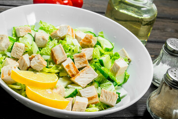 Healthy salad. Salad with cucumbers, chicken and Chinese cabbage poured lemon juice .