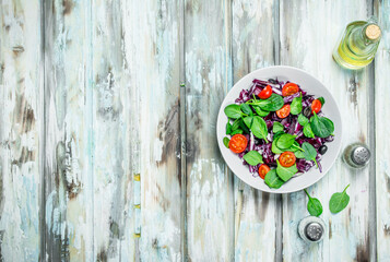 Vegetable salad. Red cabbage, tomato and spinach salad with olive oil.