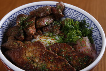 Japanese rice bowl with pork and steak slices on top