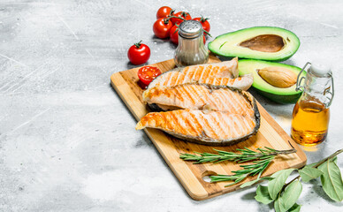 Grilled salmon steaks with vegetables on a wooden Board.