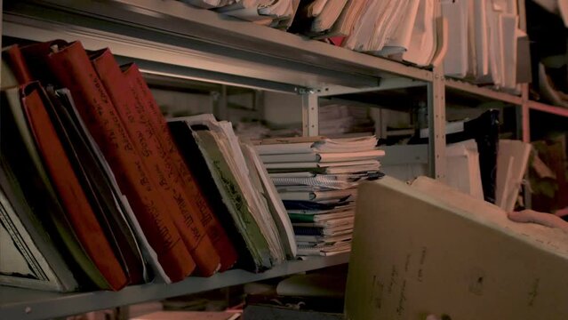 Paper archive shelf with old files, folders, documents. Storage of music lead sheets in library. Paperwork concept