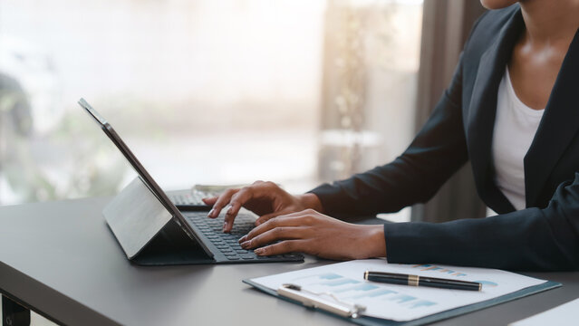 Young African American female working with tablet computer on remote project watching webinar. doing corporate data digital technology analysis.