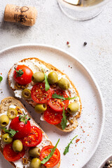 Bruschettas with olives and fresh tomatoes and wineglass