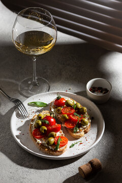 Plate with delicious bruschetta and glass of wine