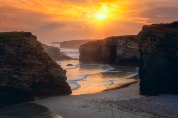 Cathedrals beach (Playa de las Catedrales) or Praia de Augas Santas at sunrise, amazing landscape with rocks on the Atlantic coast and colored sky, Ribadeo, Galicia, Spain. Outdoor travel background