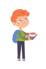 Cute kid eating healthy meal in school canteen, hungry boy standing and holding tray