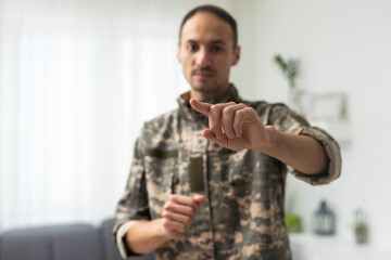 Confident masculine military man looking and pointing finger at camera