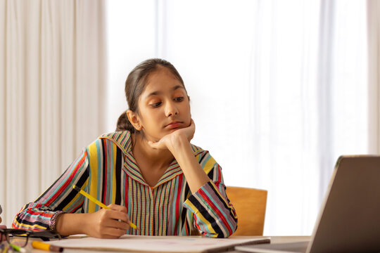 Little girl doing her online class using laptop at home
