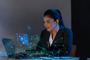 Businesswoman working on laptop computer with icons on virtual screen