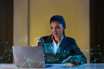 Businesswoman working on laptop computer with icons on virtual screen