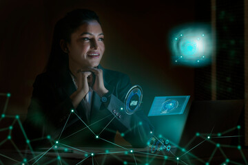 Businesswoman working on laptop computer with icons on virtual screen