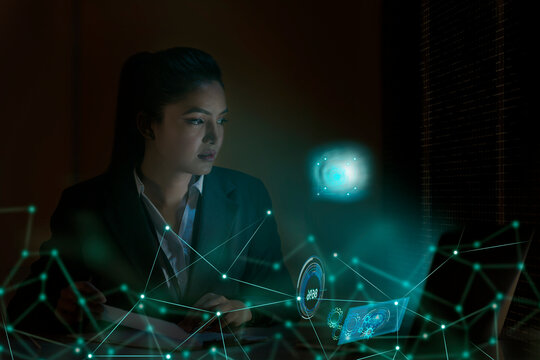 Businesswoman working on laptop computer with icons on virtual screen
