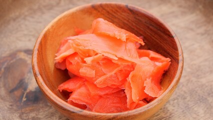 Pickled ginger slices in wooden bowl, close up