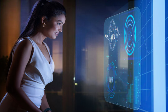 Businesswoman working with icons on virtual screen