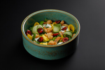 Grilled shrimps salad in bowl isolated over black background