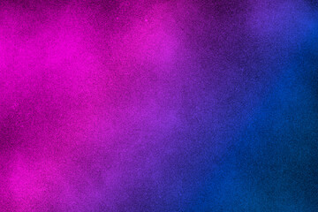 I see black, abstract background with diagonal gradient from blue to pink sprayed with black paint. Copy space for your design.