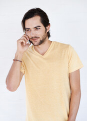 Man, phone and phone call in studio, happy and relax while standing against white background space....
