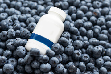 Bottle with medicine on the background of a large blueberry