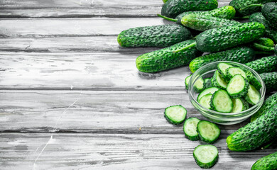 Whole cucumbers and cucumber slices in the bowl.
