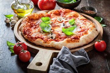Spicy Capricciosa pizza made of ham and mushrooms. Italian cuisine.