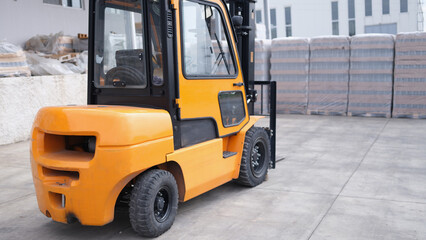 Parking forklift in logistics warehouse. Pallet stacking equipment outside and modern warehouse storage