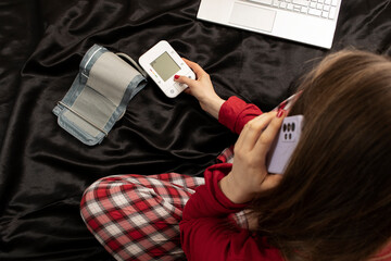 A woman with hypertension talks to a doctor on the phone. Telehealth concept.