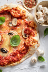 Homemade and tasty pizza with tomatoes, cheese and mushrooms.