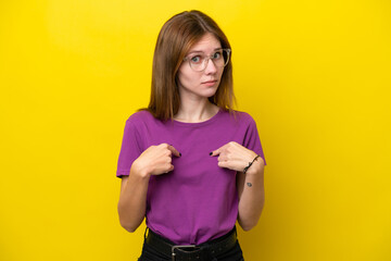 Young English woman isolated on yellow background pointing to oneself