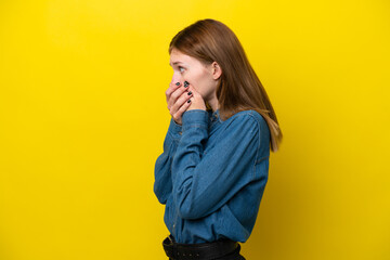 Young English woman isolated on yellow background covering mouth and looking to the side