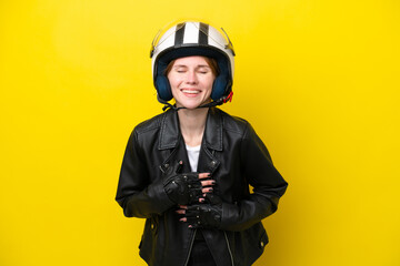 Young English woman with a motorcycle helmet isolated on yellow background smiling a lot