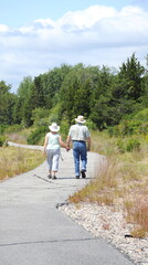 Man and woman walking on a trail outside.
